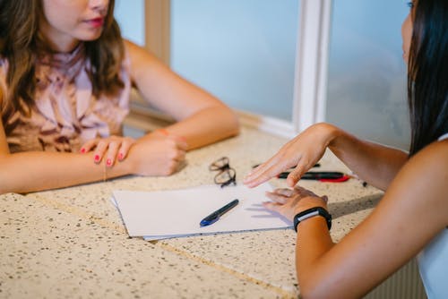 A mentor works with their mentee to explain a concept. 